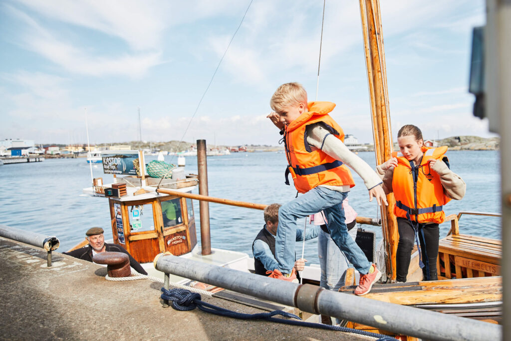 Barn hoppar iland från fiskebåten Kastor